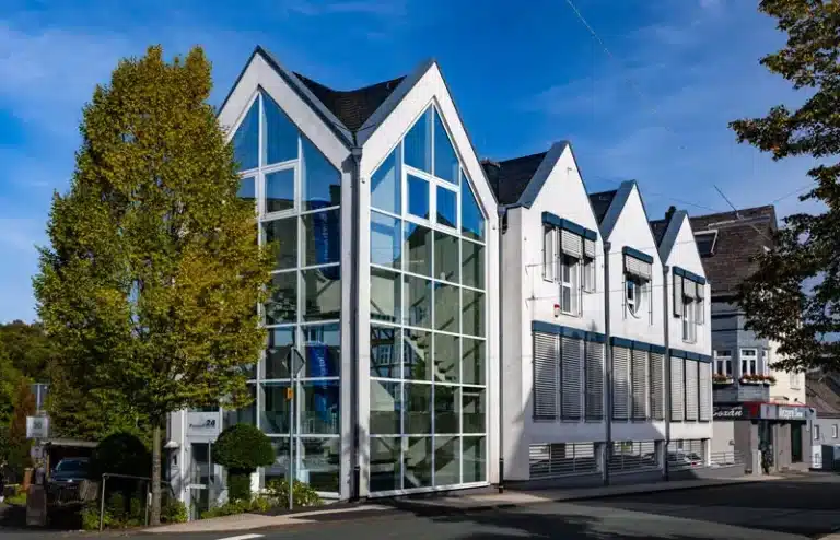 Modernes Bürogebäude mit Glasfassade und grüner Umgebung